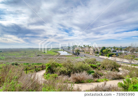 Panoramic landscape of Huntington Beach with road grass land pond and buildings Panoramic landscape of Huntington Beach with road grass land pond and buildings 78905990