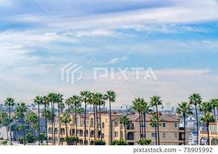 Residential building exterior against cloudy blue sky in scenic Huntington Beach Residential building exterior against cloudy blue sky in scenic Huntington Beach 78905992