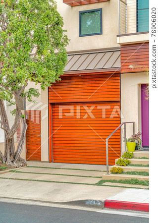 Home exterior with brown garage door and roof overhang in Long Beach California 78906020