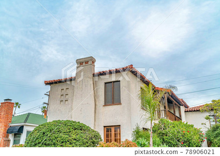 Exterior of two storey house with concerete wall balcony and chimney against sky 78906021