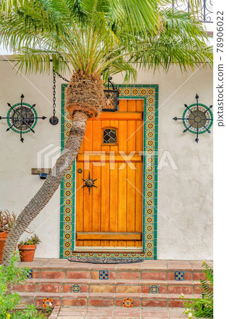 Brown wooden front door framed with decorative tiles in Long Beach California Brown wooden front door framed with decorative tiles in Long Beach California 78906022