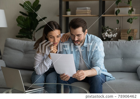 Curious interested young couple reading paper letter. Curious interested young couple reading paper letter. 78906462