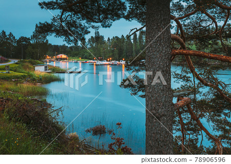 Sweden. Road To Beautiful Swedish Village near Lake. Wooden Log Cabin Houses In Summer Evening Night. Lake Or River Landscape 78906596