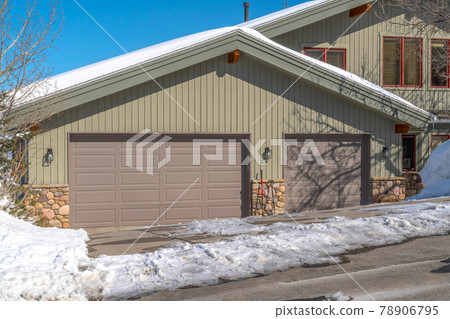 Facade of an attached garage with gray doors and gable roof in Park City Utah Facade of an attached garage with gray doors and gable roof in Park City Utah 78906795