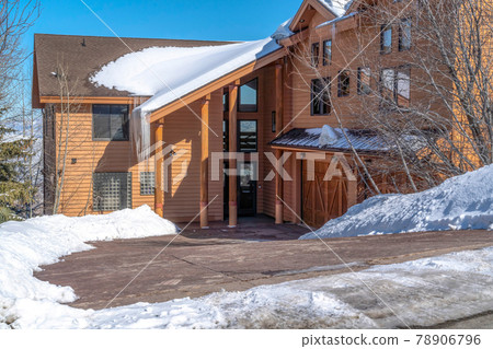 Facade of Park City Utah mountain home with brown exterior wall and snowy roof 78906796