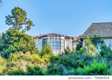 Home exterior with bay window against blue sky and green foliage on a sunny day Home exterior with bay window against blue sky and green foliage on a sunny day 78906859