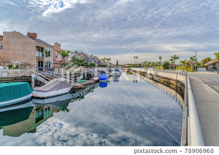Overcast sky reflected on canal with docks and boats in Huntington Beach CA 78906968