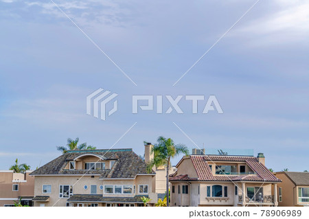 Houses with attics and balcony against cloudy sky in Huntington Beach California 78906989