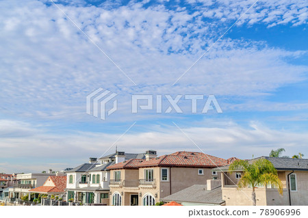Blue sky and puffy clouds over houses in a prestigious seaside neighborhood 78906996