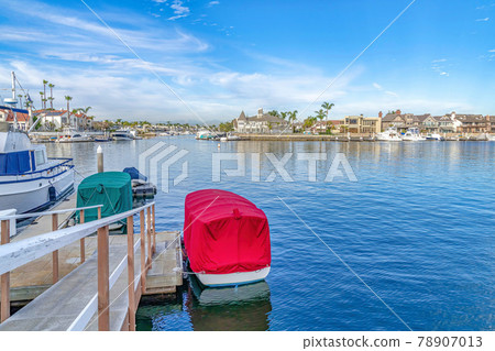 Serene sea reflecting blue sky in scenic Huntington Beach with waterfront houses 78907013