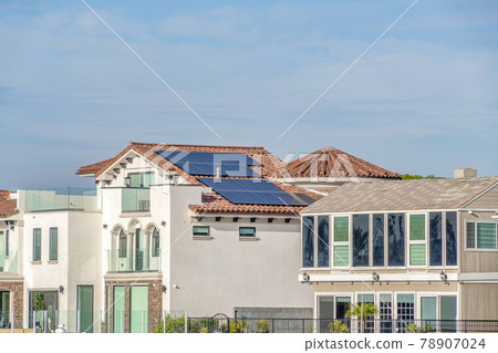 House with white exterior wall and solar panels on tile roof in Huntington Beach 78907024
