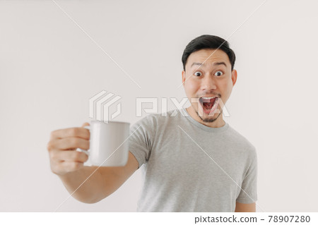 Surprised face of man drinks a cup of coffee isolated on white background. 78907280