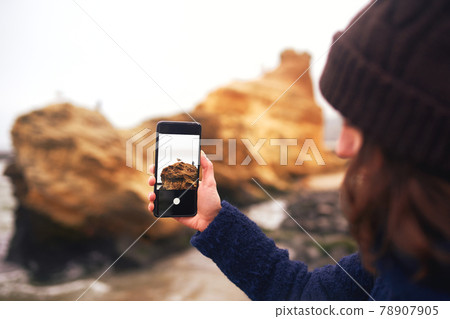 Young woman traveler using mobile phone on beach 78907905
