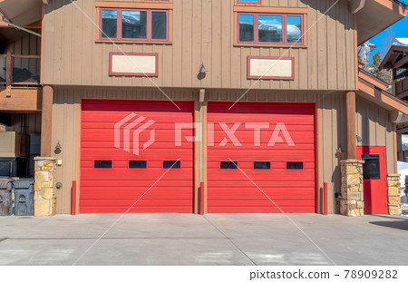 Entrance to the garage with red door of a home in Park City Utah on a sunny day 78909282