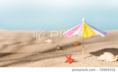 Sunshade umbrella on a sandy beach with seashells. Summer vacation concept.Summer background. 78909358