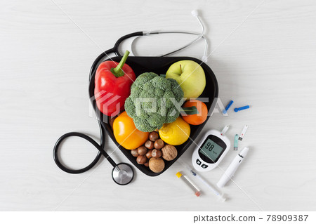 Fresh vegetables and fruit with glucometer top view on white wooden background. 78909387