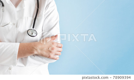 Doctor in a lab coat with stethoscope over blue background. 78909394