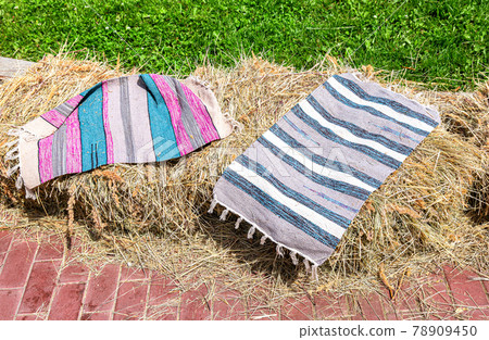 Handmade striped rugs lie on the hay Handmade striped rugs lie on the hay 78909450
