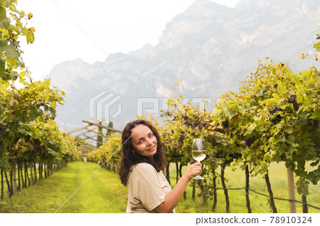 Young woman with a glass of white wine in the vineyards of Italy. Person pouring wine. Free space Young woman with a glass of white wine in the vineyards of Italy. Person pouring wine. Free space 78910324