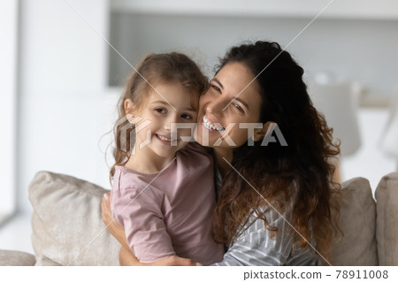 Happy Hispanic mom and daughter hug at home Happy Hispanic mom and daughter hug at home 78911008