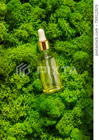 Dropper glass Bottle Mock-Up on green moss background. Body treatment and spa. Natural beauty products. Eco cream, serum, skin care blank bottle. Anti-cellulite massage oil. Oily cosmetic pipette 78912929