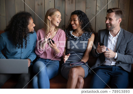 Happy young mixed race friendly people using different gadgets. Happy young mixed race friendly people using different gadgets. 78913893
