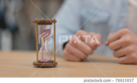 Close up of Male Hands Near Hourglass 78915057