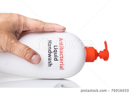 Dry skin on finger with bottle of antibacterial liquid handwash. Frequent hand washing causes skin dryness Dry skin on finger with bottle of antibacterial liquid handwash. Frequent hand washing causes skin dryness 78916850