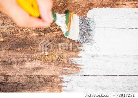 hand using paintbrush decorating or painting old wood brown color to white color hand using paintbrush decorating or painting old wood brown color to white color 78917251