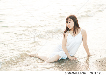 One-piece woman sitting on the beach One-piece woman sitting on the beach 78917346