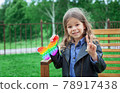 Caucasian little girl playing with pop it silicone trendy rainbow colow toy 78917438