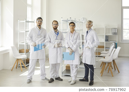 Diverse scientist group standing at laboratory looking at camera portrait Diverse scientist group standing at laboratory looking at camera portrait 78917902