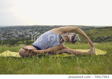Middle aged man stretching body in countryside Middle aged man stretching body in countryside 78917903