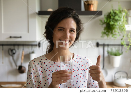 Head shot portrait smiling woman showing thumb up, drinking water Head shot portrait smiling woman showing thumb up, drinking water 78918896