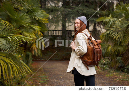 Rear view on modern tourist woman with backpack having excursion in garden Rear view on modern tourist woman with backpack having excursion in garden 78919718