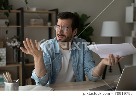 Frustrated young man feeling stressed of reading bad news. Frustrated young man feeling stressed of reading bad news. 78919793