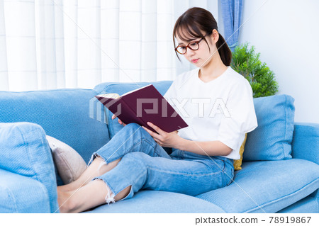 戴眼鏡在沙發上看書的女人 78919867