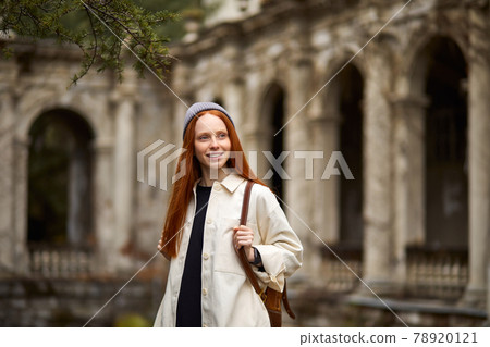 Happy caucasian female Traveler with backpack walking in historical site 78920121
