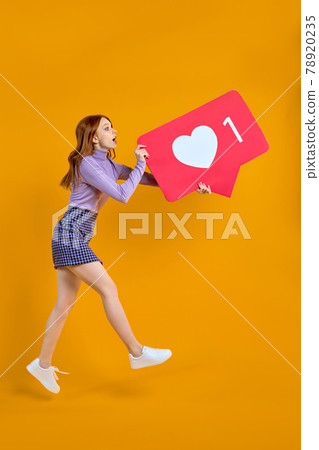 female chasing likes, jumping woman keeping heart social media icon looking copyspace 78920235