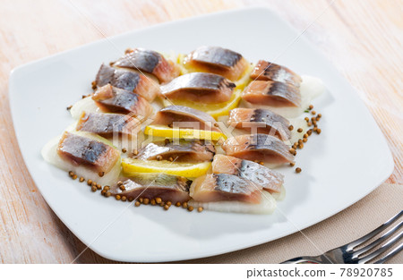 Marinated herring with sliced onion and lemon 78920785