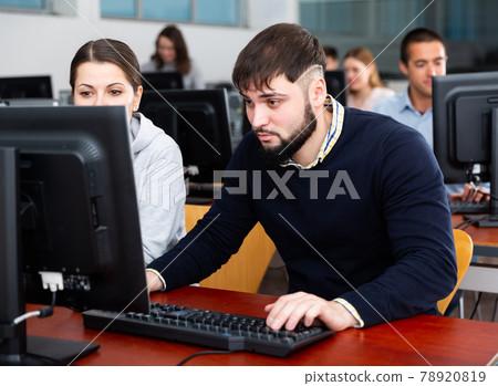 Man and woman study together in university computer class Man and woman study together in university computer class 78920819