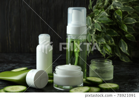 Concept of cucumber cosmetics on black smokey table Concept of cucumber cosmetics on black smokey table 78921091