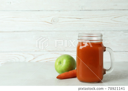 Glass jar of juice and ingredients against white wooden background Glass jar of juice and ingredients against white wooden background 78921141