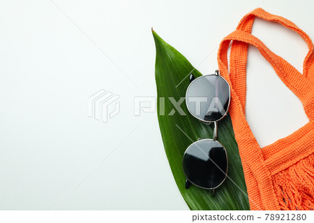 String bag, palm leaf and sunglasses on white background 78921280