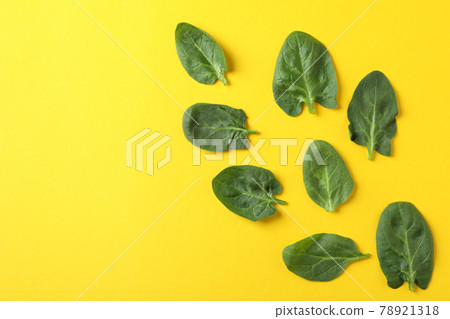 Fresh raw spinach leaves on yellow background 78921318