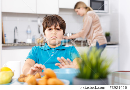 Displeased boy refusing to eat 78921436
