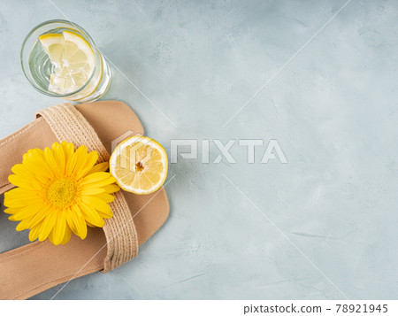 Summer fashion concept with straw sandals on turquoise background with yellow flowers and lemons Summer fashion concept with straw sandals on turquoise background with yellow flowers and lemons 78921945