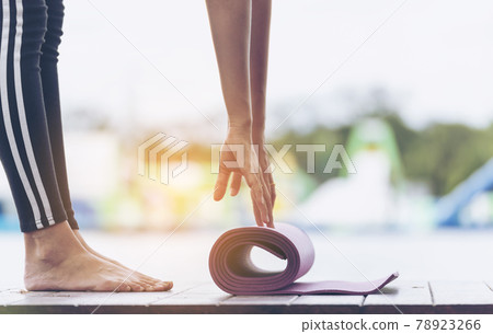 Woman hands rolled up yoga mat outdoor workout. Close up hands rolling foam yoga gym mat outside morning exercise. Woman stretching workout sportive healthy lifestyle on street city town park concept Woman hands rolled up yoga mat outdoor workout. Close up hands rolling foam yoga gym mat outside morning exercise. Woman stretching workout sportive healthy lifestyle on street city town park concept 78923266