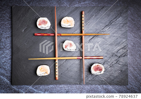 Three in a row made with sushi and chopsticks. Delicious Japanese food Three in a row made with sushi and chopsticks. Delicious Japanese food 78924637