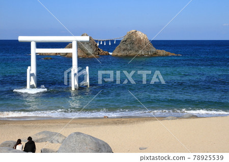 一對夫婦在絲島海岸看櫻井二見浦的夫妻岩和白鳥 78925539